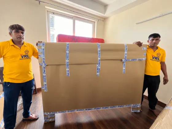 Two VRL packers holding a corrugated-wrapped bed panel